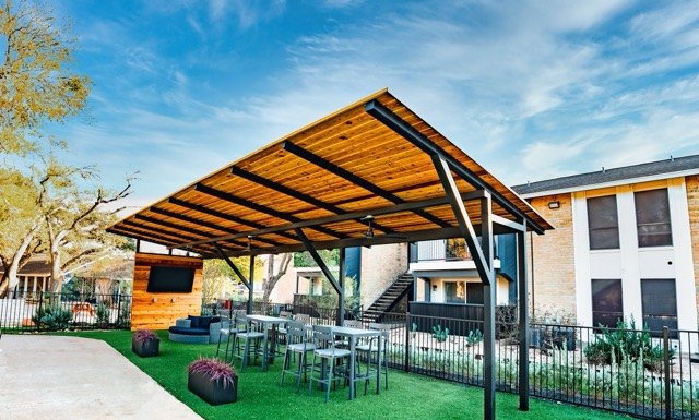 Steel pavilion over a turf lawn with lounge seating