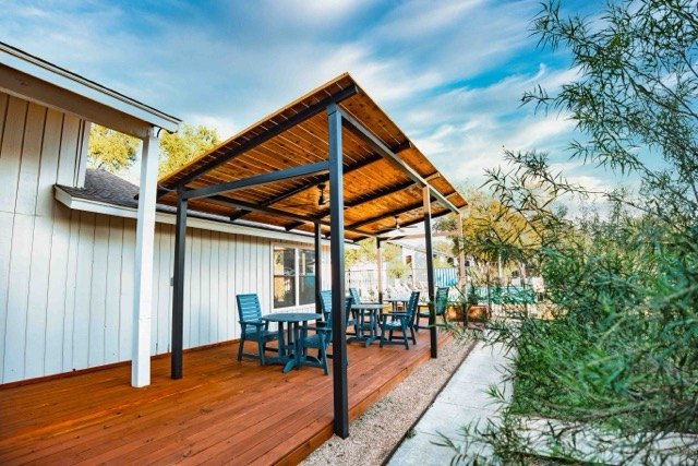Covered patio with tables beside an apartment building