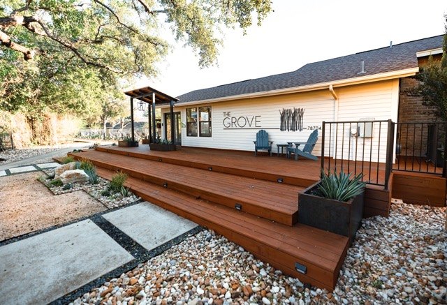 Wide wood deck with planters along a renovated building