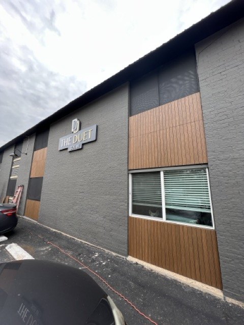 Building facade in dark paint with wood accent panels