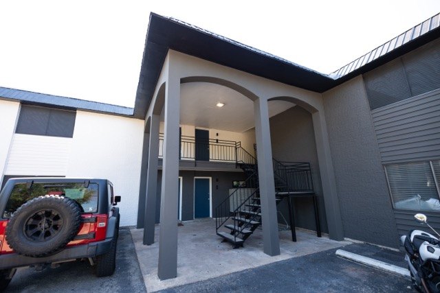Stairwell entry with a new arched overhang and dark paint