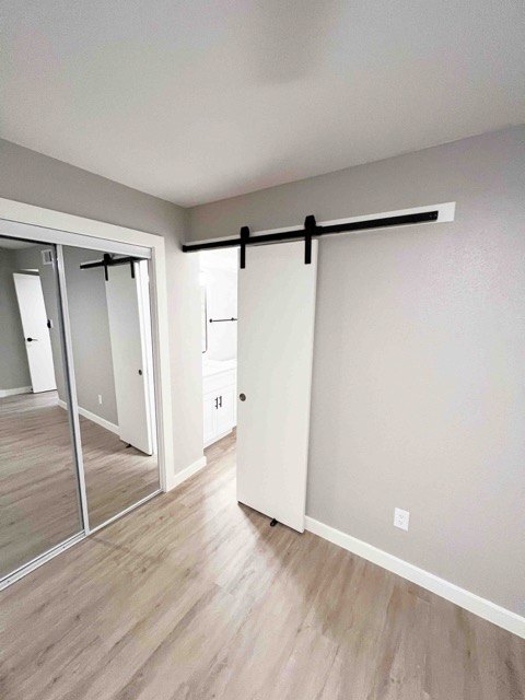 Renovated bedroom with a sliding barn door and plank flooring