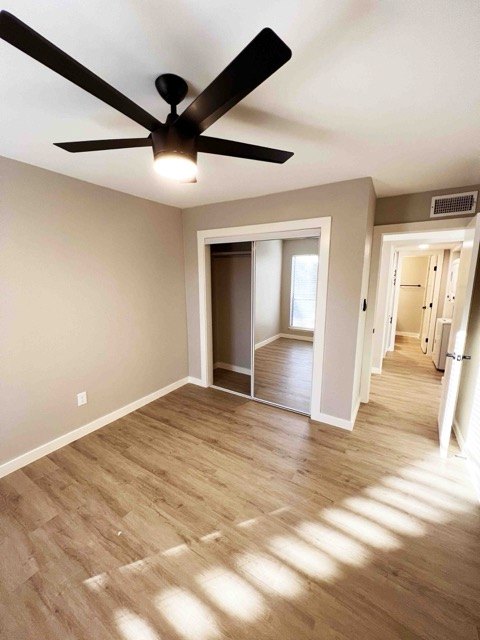 Bedroom with a black ceiling fan and plank flooring